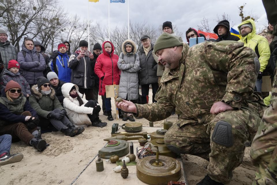 An instructor, right, shows a grenade during a training of members of a Ukrainian far-right group train, in Kyiv, Ukraine, Sunday, Feb. 20, 2022. Russia extended military drills near Ukraine's northern borders Sunday amid increased fears that two days of sustained shelling along the contact line between soldiers and Russa-backed separatists in eastern Ukraine could spark an invasion. (AP Photo/Efrem Lukatsky)