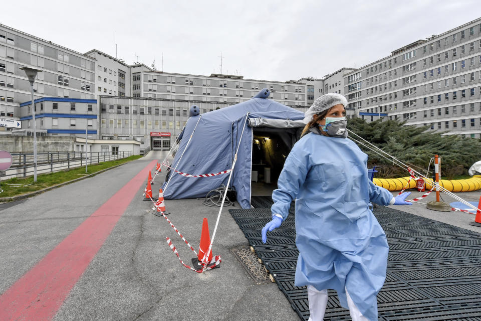 A paramedic walks out of a tent that was set up in front of the emergency ward of the Cremona hospital, northern Italy, Saturday, Feb. 29, 2020. A U.S. government advisory urging Americans to reconsider travel to Italy due to the spread of a new virus is the “final blow” to the nation's tourism industry, the head of Italy's hotel federation said Saturday. (Claudio Furlan/Lapresse via AP)