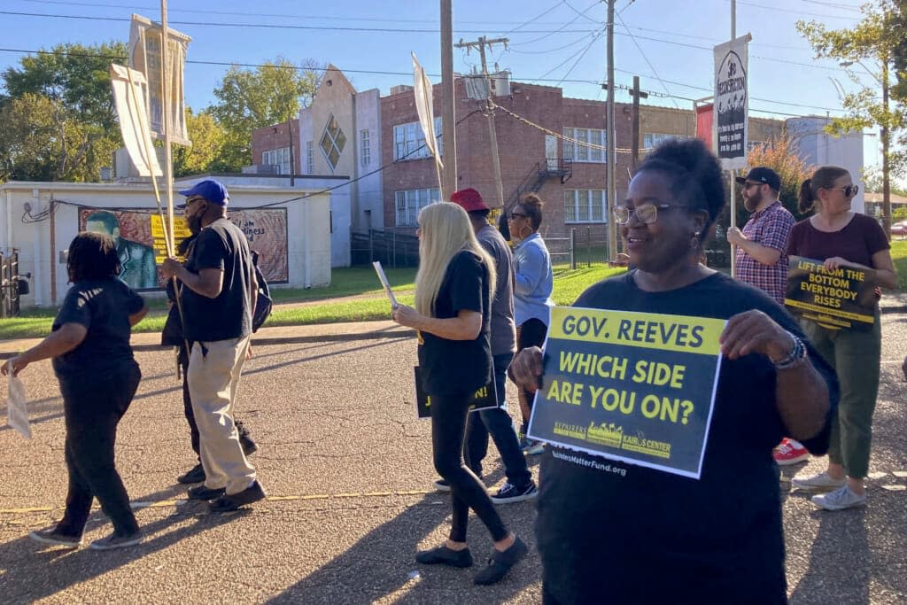 A protestor holds a sign aimed at Mississippi Gov. Tate Reeves during a protest on Monday, Sept. 26, 2022 in Jackson, Miss. Reeves, a Republican, blames Jackson’s water crisis on mismanagement at the city level. (AP Photo/Michael Goldberg)