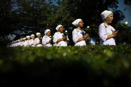 Thai women devotees in white robes walk in line during a mass female Buddhist novice monk ordination ceremony at the Songdhammakalyani monastery, Nakhon Pathom province, Thailand, December 5, 2018. REUTERS/Athit Perawongmetha