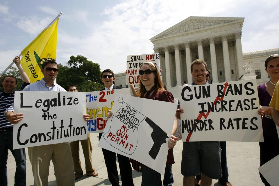 Pro-rights gun supporters hold up their banners outside the Supreme Court in Washington on June 26, 2008, after the court ruled that Americans have a constitutional right to keep guns in their homes for self-defense, the justices' first major pronouncement on gun control in U.S. history.
