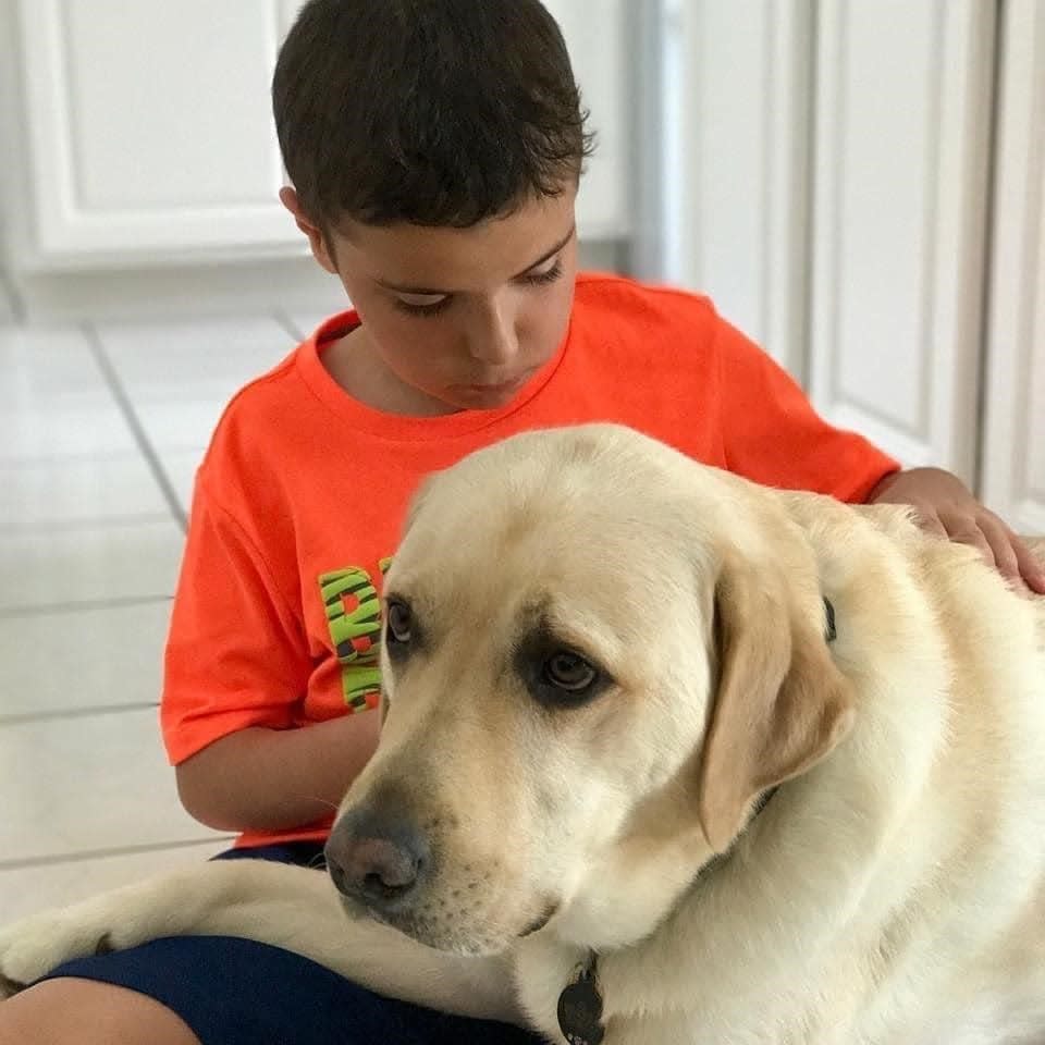 Ryan Lawrence, at a younger age, with his service dog Ian.