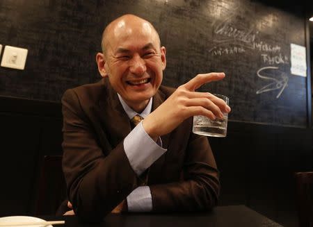 Shiro Fukai, 48, smiles as he drinks distilled spirit at the Otasuke "izakaya" style pub and restaurant in Tokyo May 8, 2014. REUTERS/Toru Hanai