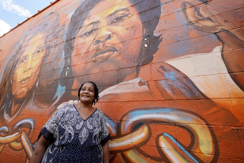 Jacqueline Hamer Flakes, the adopted daughter of civil rights icon Fannie Lou Hamer, stands beneath the mural of her mother painted on the side of the Council of Federated Organizations building in Jackson, Miss., Saturday, July 24, 2021. Flakes' mother was one of several civil rights legends, living and dead, honored by the Jackson State University's Office of Community Engagement with the unveiling of its "Chain Breakers" mural at the COFO building. (AP Photo/Rogelio V. Solis)
