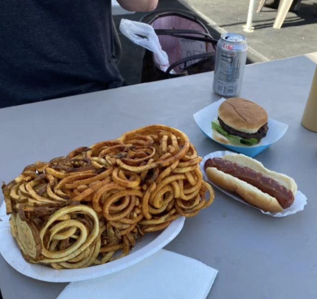 a large chunk of curly fries still in the shape of the fryer basket they just came out of