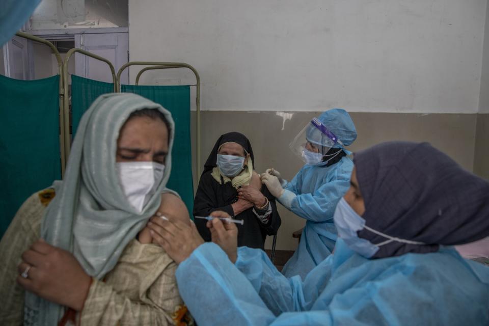 Kashmiri women receive vaccines.