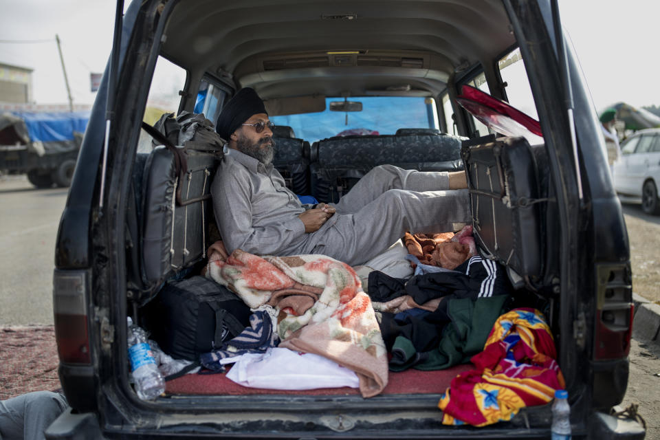 Savek Singh, 48, rests inside his vehicle parked on a highway as he joins a farmers protest, at the Delhi-Haryana state border, India, Tuesday, Dec. 1, 2020. The farmers are protesting new laws they say will result in their exploitation by corporations, eventually rendering them landless. Prime Minister Narendra Modi's government, rattled by the growing rebellion, insists the reforms will benefit them. But the farmers aren’t yielding. (AP Photo/Altaf Qadri)