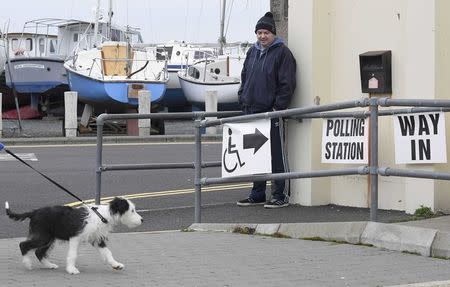 A voter stands outside a boathouse being used as a polling station, on polling day for the Northern Ireland Assembly elections, at Groomsport near Bangor in Northern Ireland, March 2, 2017. REUTERS/Toby Melville