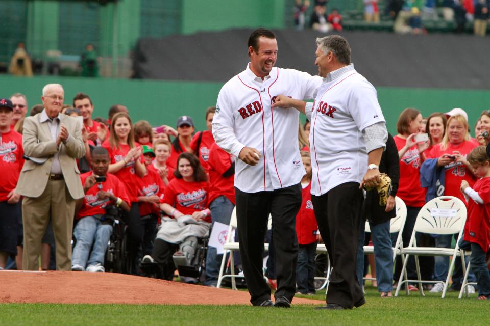 Boston knuckleball pitcher Tim Wakefield jokes with his longtime catcher, Doug Mirabelli, before a game in 2012 that honored Wake for his many years with the Red Sox.