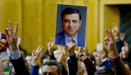 A supporter holds a portrait of Selahattin Demirtas, detained leader of Turkey's pro-Kurdish opposition Peoples' Democratic Party (HDP) at a meeting at the Turkish parliament in Ankara, Turkey, November 8, 2016, in the absence of Demirtas and other HDP lawmakers who were jailed after refusing to give testimony in a probe linked to "terrorist propaganda". REUTERS/Umit Bektas/File Photo