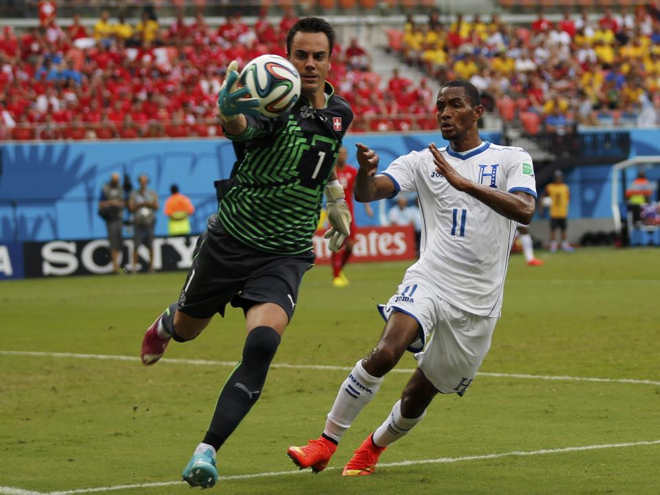 Switzerland's goalkeeper Diego Benaglio (L) fights for the ball with Jerry Bengtson of Honduras during their 2014 World Cup Group E soccer match at the Amazonia arena in Manaus June 25, 2014. REUTERS/Siphiwe Sibeko (BRAZIL - Tags: SOCCER SPORT WORLD CUP)