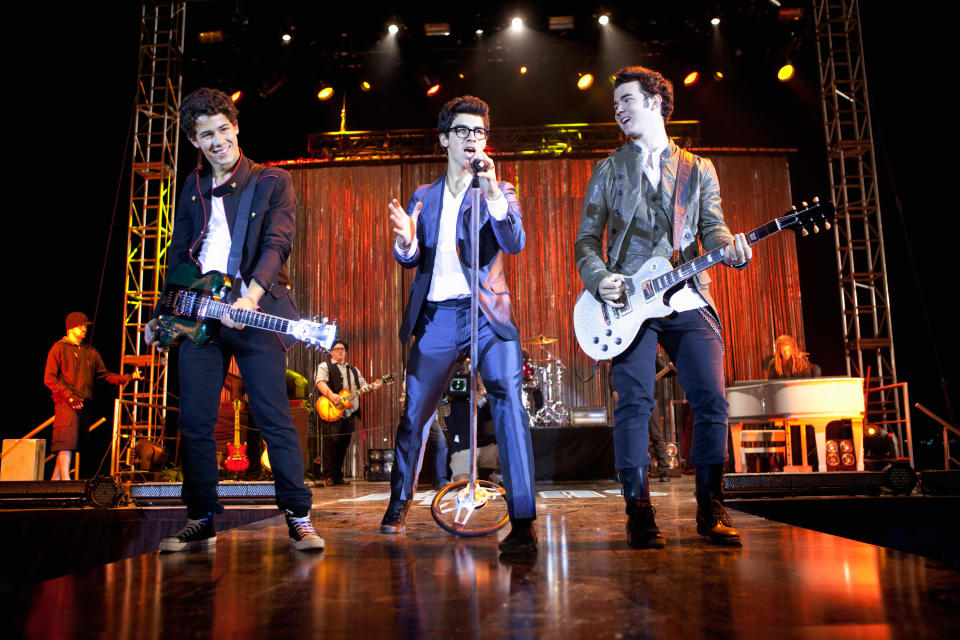 The Jonas brothers performing onstage in the show