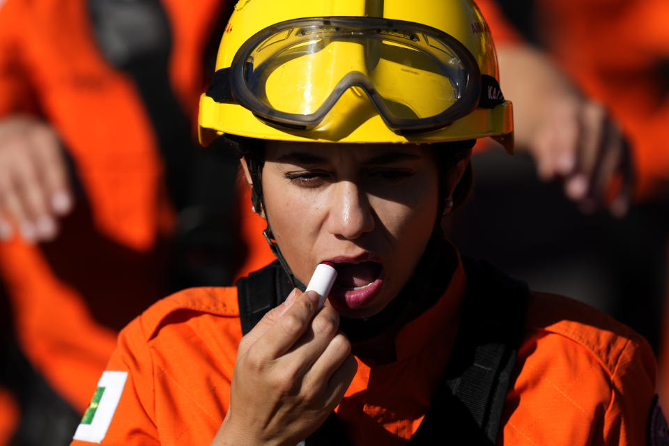 A member of the Military Fire Battalion applies lipstick before parading at a military parade on Independence Day in Brasilia, Brazil, Thursday, Sept. 7, 2023. (AP Photo/Eraldo Peres)