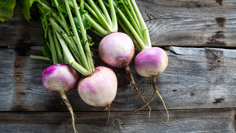 four turnips on wooden table