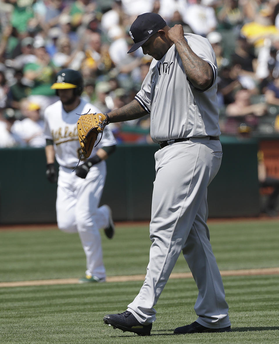 New York Yankees pitcher CC Sabathia, right, reacts after walking Oakland Athletics' Matt Olson with the bases loaded to allow Jed Lowrie, rear, to score during the first inning of a baseball game in Oakland, Calif., Monday, Sept. 3, 2018. (AP Photo/Jeff Chiu)