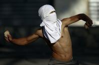 An anti-government protester throws stones at the police during clashes at Altamira square in Caracas March 3, 2014. Jailed Venezuelan opposition leader Leopoldo Lopez urged sympathizers on Monday to maintain street protests against President Nicolas Maduro as the country's foreign minister prepared to meet the United Nations Secretary General. REUTERS/Jorge Silva