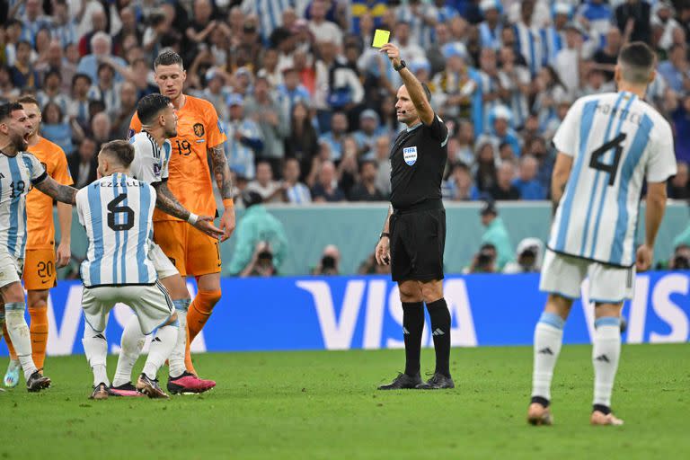 Spanish referee Antonio Mateu Lahoz shows a yellow card to Argentina's midfielder #05 Leandro Paredes during the Qatar 2022 World Cup quarter-final football match between Netherlands and Argentina at Lusail Stadium, north of Doha, on December 9, 2022. (Photo by Alberto PIZZOLI / AFP)