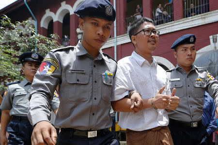 Detained Reuters journalist Wa lone is escorted by police officers as he leaves Insein court in Yangon, Myanmar, July 23, 2018. REUTERS/Ann Wang
