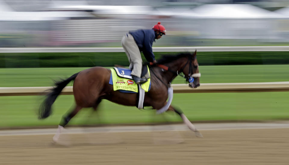 In this image taken with a slow shutter speed, exercise rider Kelvin Pahal takes Kentucky Derby hopeful Wicked Strong for a morning workout at Churchill Downs Tuesday, April 29, 2014, in Louisville, Ky. (AP Photo/Morry Gash)