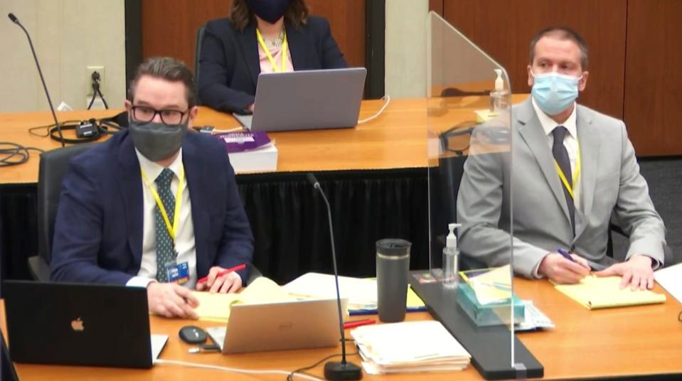 In this image from video, defense attorney Eric Nelson, left, and defendant former Minneapolis police Officer Derek Chauvin listen as Assistant Minnesota Attorney General Matthew Frank, questions witness Christopher Martin.