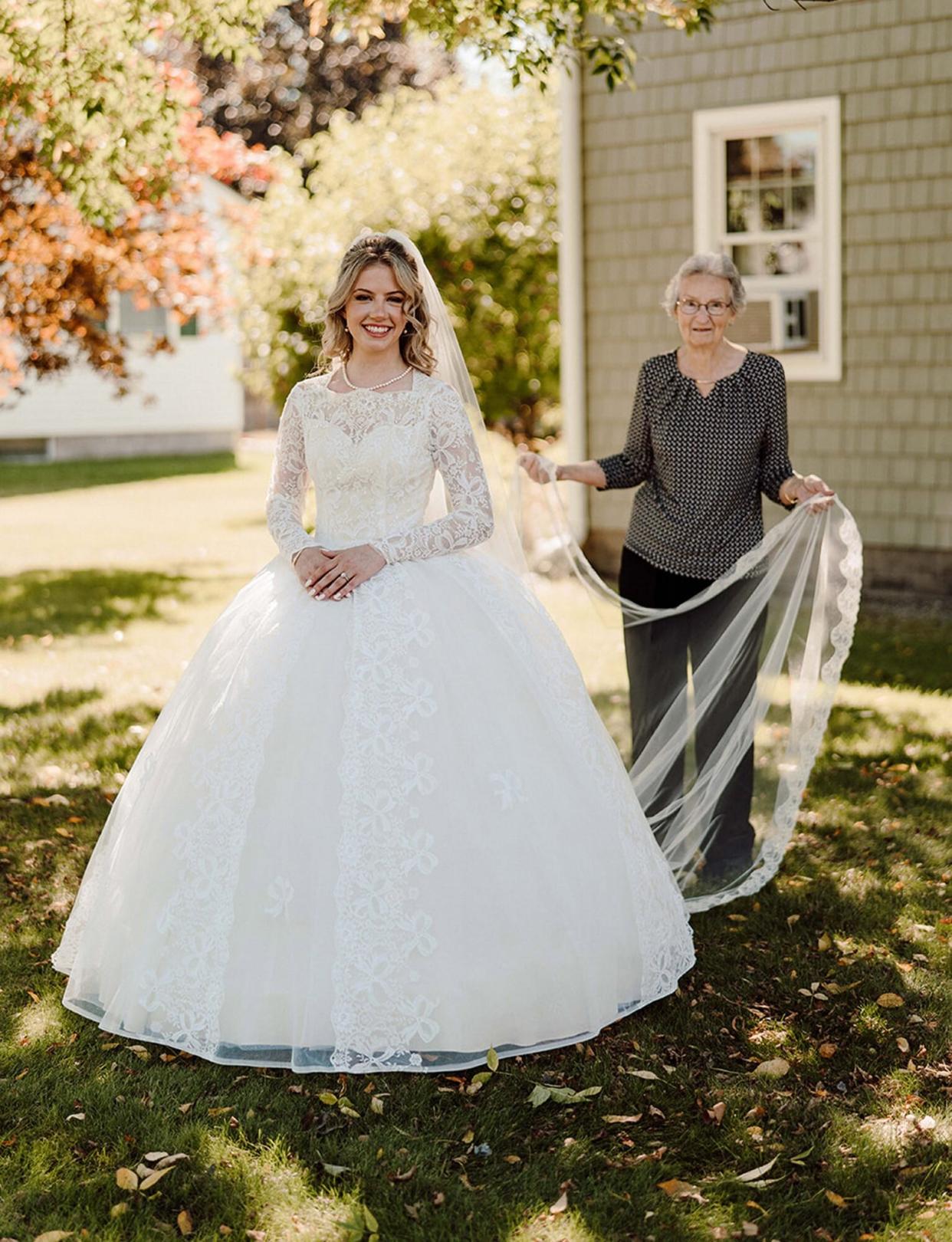 @keptyaphotography / MERCURY PRESS (PICTURED L-R Allie Livingwater and grandmother Anne Cooke) This woman has something borrowed and something old as she walked down the aisle wearing her grandma's 60-year-old wedding dress. Allie Livingwater, 23, tied the knot with Timothy, 27, on September 25 [2021] wearing her grandma Anne Cooke, 88, dress. The white laced gown was discovered in a black bin liner in 2016 and Allie immediately knew she wanted to wear it as 'something borrowed'. The long-sleeved dress required zero alterations but needed a clean after being stored in the basement since 1961. SEE MERCURY COPY