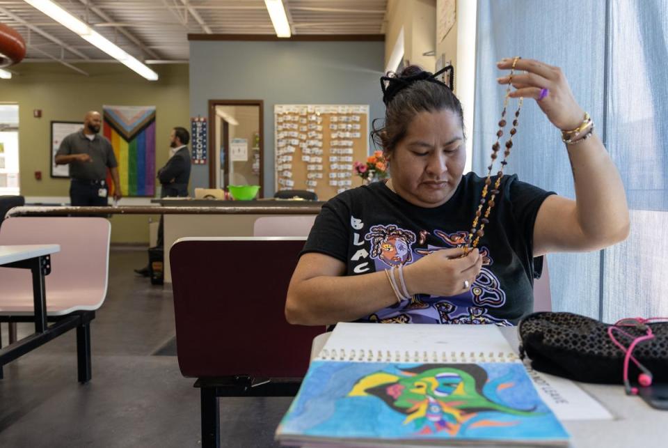 Ana Y., 35, looks through jewlery and drawings she's made at the Tarrant County MHMR's community center on August 15, 2023. 