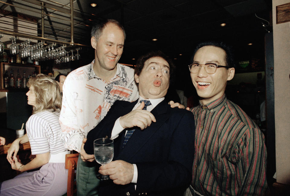 FILE - In this July 21, 1988, file photo, comedian Jackie Mason, holding a glass, enjoys a joke with John Lithgow, left, and B.D. Wong, stars of the Tony award-winning Broadway show "M. Butterfly," at the Stage Deli in New York. Mason hosted a late-night supper party in honor of the 1988 Tony winners and Broadway's summer season. Mason, a rabbi-turned-jokester whose feisty brand of standup comedy got laughs from nightclubs in the Catskills to West Coast talk shows and Broadway stages, has died. He was 93. Mason died Saturday, July 24, 2021, in Manhattan, the celebrity lawyer Raoul Felder told The Associated Press. (AP Photo/Adam Stoltman, File)