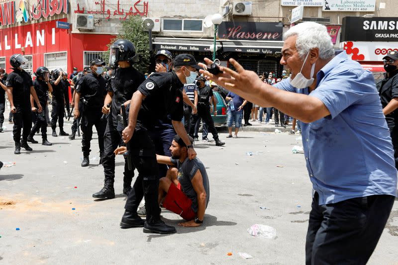 Un hombre reacciona mientras la policía detiene a un manifestante durante una protesta contra el gobierno en Túnez