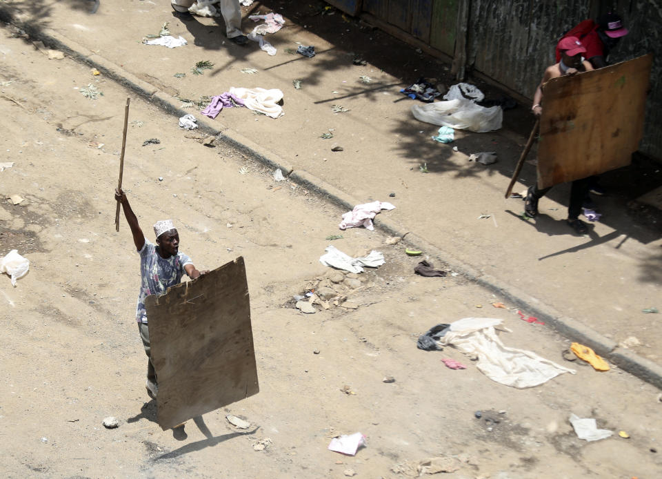 Two Nubian community residents hold wooden shields after a fight broke out among Leo and Nubi community during a mass rally called by the opposition leader Raila Odinga over the high cost of living in Kibera Slums, Nairobi, Monday, March 27, 2023. Police in Kenya are on high alert ahead of the second round of anti-government protests organized by the opposition that has been termed as illegal by the government. Police chief Japheth Koome insists that Monday's protests are illegal but the opposition leader Raila Odinga says Kenyans have a right to demonstrate.(AP Photo/Brian Inganga)