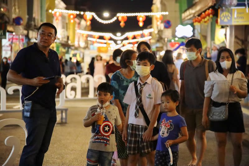 People wearing protective face maks are seen at a walking street in Phuket