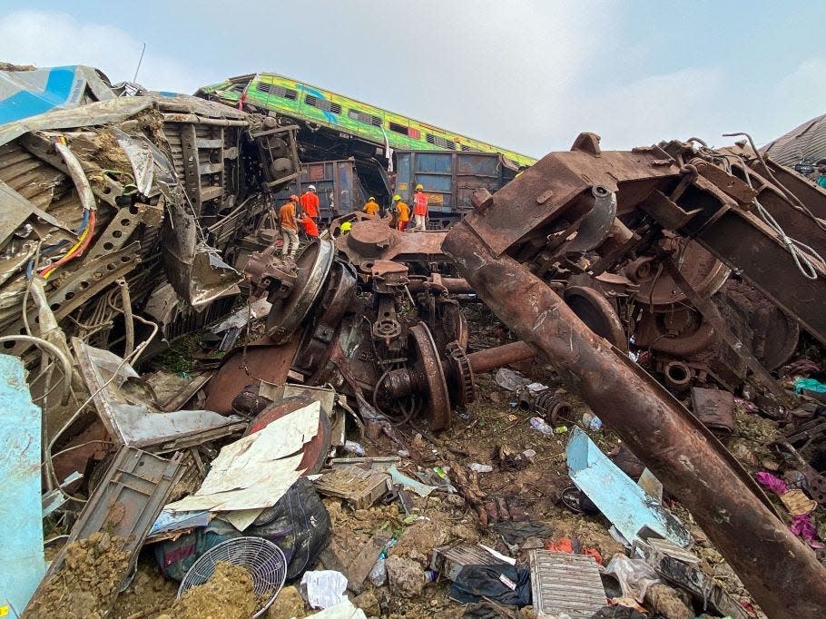 Rescue workers search for survivors at the accident site of a three-train collision near Balasore.