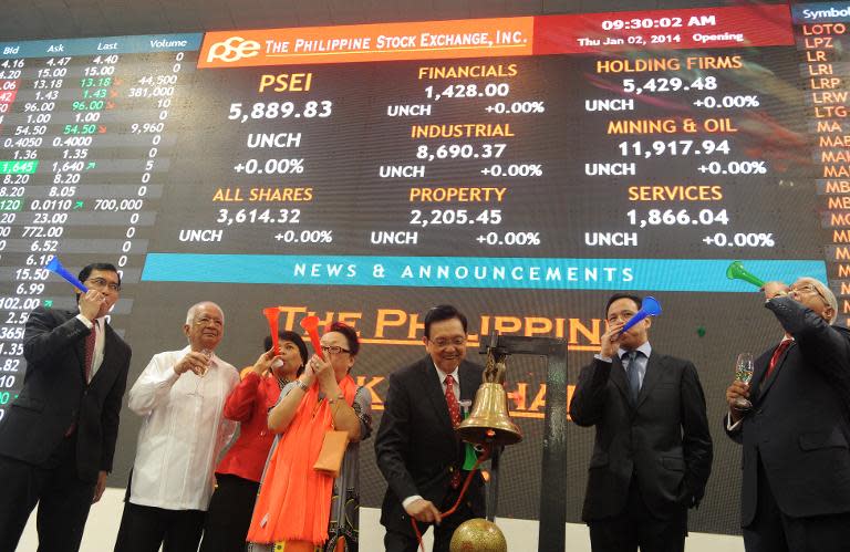 Officials ring the bell and blow horns to mark the first trading day of the year at the Philippine Stock Exchange in Manila on January 2, 2014