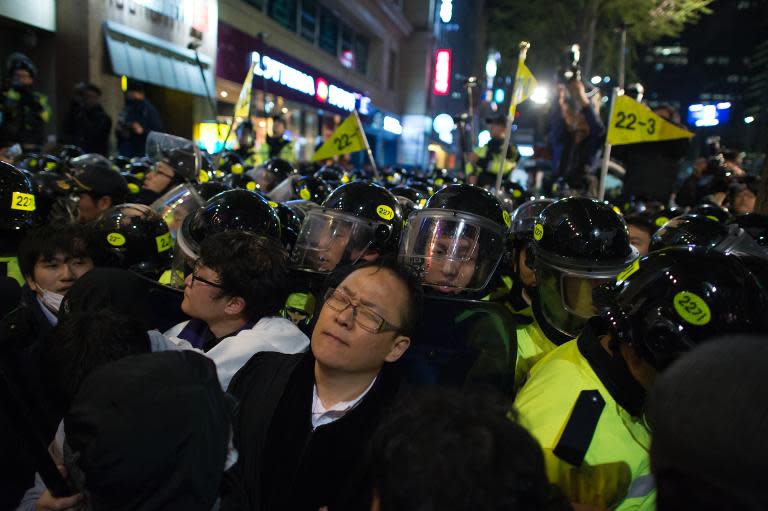 Mourners clash with police during a march to commemorate the first anniversary of the Sewol ferry disaster, in Seoul on April 16, 2015