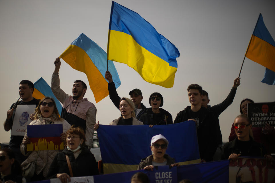 People shout slogans during a protest by pro-Ukraine people against Russia's invasion of Ukraine, in Istanbul, Turkey, Tuesday, March 29, 2022. Mykhailo Podolyak, adviser to Ukrainian President Volodymyr Zelenskyy, says the talks under way with Russia in Istanbul are focusing on security guarantees for Ukraine and hopes of a cease-fire. (AP Photo/Francisco Seco)