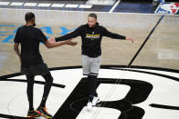 Golden State Warriors guard Stephen Curry, right, and Brooklyn Nets forward Kevin Durant, former teammates, greet each other at center court before an NBA basketball game Tuesday, Dec. 22, 2020, in New York. (AP Photo/Kathy Willens)