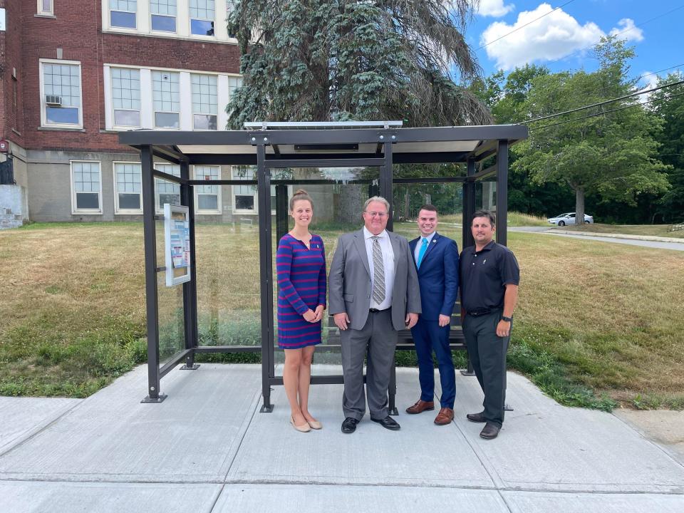 Gardner City Council President Elizabeth Kazinskas, MART Administrator Bruno Fisher, Mayor Michael J. Nicholson and Ward Five City Councilor Aleksander Dernalowicz pose for a photo in front of the first new bus stop and shelter installed at the site of the former Prospect Street School.