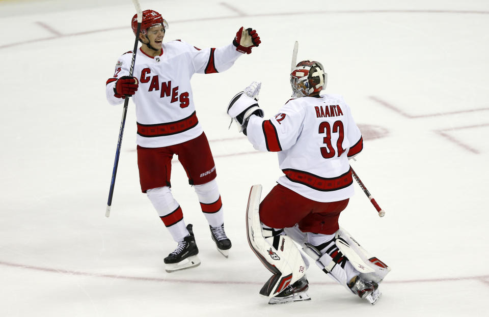 Carolina Hurricanes goalie Antti Raanta (32) celebrates with teammate Jester Kotkaniemi, left, after winning in a shootout in an NHL hockey game against the New Jersey Devils, Sunday, Jan. 1, 2023, in Newark, N.J. (AP Photo/John Munson)