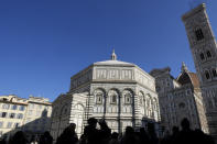 People look at St. John's Baptistery, one of the oldest churches in Florence, central Italy, Tuesday, Feb. 7, 2023. The Baptistery's dome is undergoing a restoration work that will be done from an innovative scaffolding shaped like a giant mushroom that will stand for the next six years in the center of the church, and that will be open to visitors allowing them for the first and perhaps only time, to come come face to face with more than 1,000 square meters of precious mosaics covering the dome. (AP Photo/Andrew Medichini)