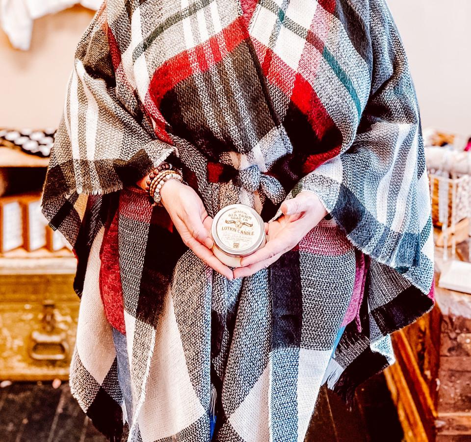 The cozy plaid wrap and candle that also doubles as body lotion have been two hot sellers these holidays at Folly Boutique in Fountain City.