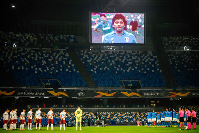 Una pantalla muestra una foto de la leyenda del fútbol argentino Diego Maradona mientras los jugadores guardan un minuto de silencio en homenaje a Maradona antes del partido de fútbol del Grupo F de la UEFA Europa League Napoli vs Rijeka el 26 de noviembre de 2020 en el estadio San Paolo de Nápoles