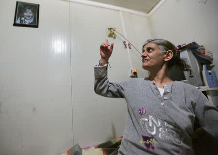 Aida Nuh looks at a picture of her lost daughter Christina Ezzo Abada during an interview with Reuters at a camp for refugee people in Erbil, Iraq, November 29, 2016. Picture taken November 29, 2016. REUTERS/Azad Lashkari