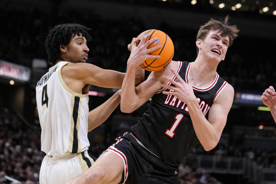 Davidson guard Reed Bailey (1) grabs a rebound over Purdue forward Trey Kaufman-Renn (4) in the first half of an NCAA college basketball game in Indianapolis, Saturday, Dec. 17, 2022. (AP Photo/Michael Conroy)