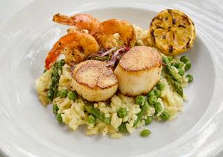 Seared Jumbo New Bedford Scallops and Gulf Shrimp served with Parmesan Risotto mixed with asparagus and spring peas. Mother's Day weekend special at Fish City Grill