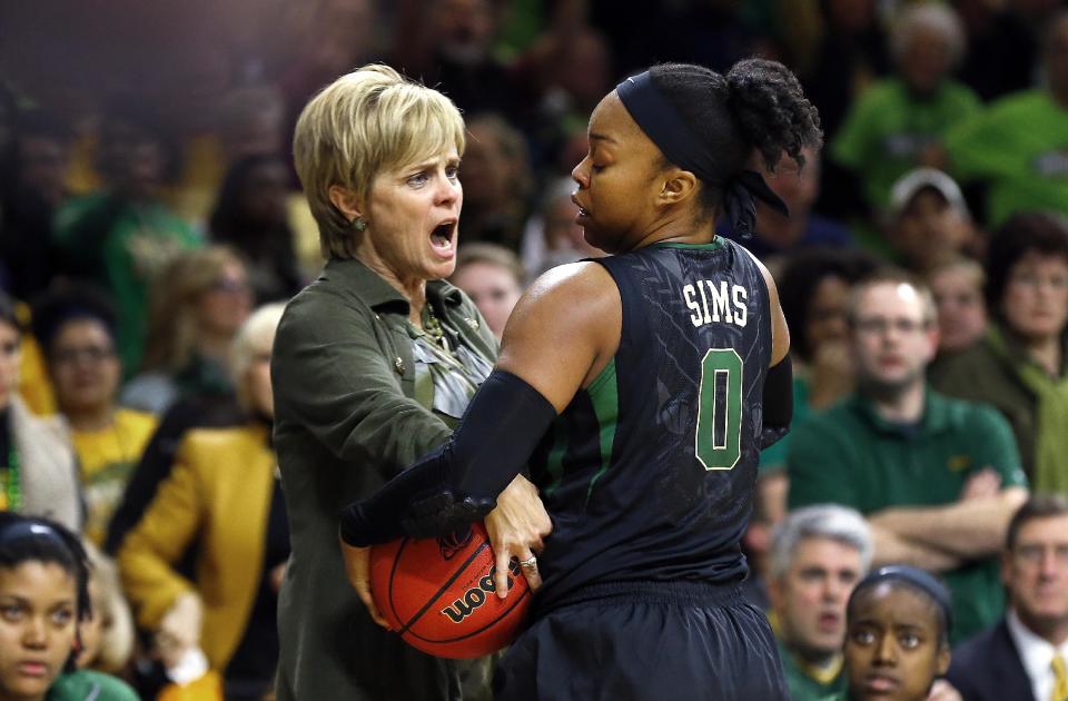 Baylor head coach Kim Mulkey tries grabbing the ball from Baylor guard Odyssey Sims during a stoppage in play against Notre Dame in the second half of their NCAA women's college basketball tournament regional final game at the Purcell Pavilion in South Bend, Ind., Monday, March 31, 2014. (AP Photo/Paul Sancya)