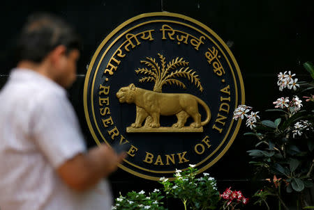 A man checks his phone outside the Reserve Bank of India (RBI) headquarters in Mumbai, India April 5, 2018. REUTERS/Francis Mascarenhas/Files