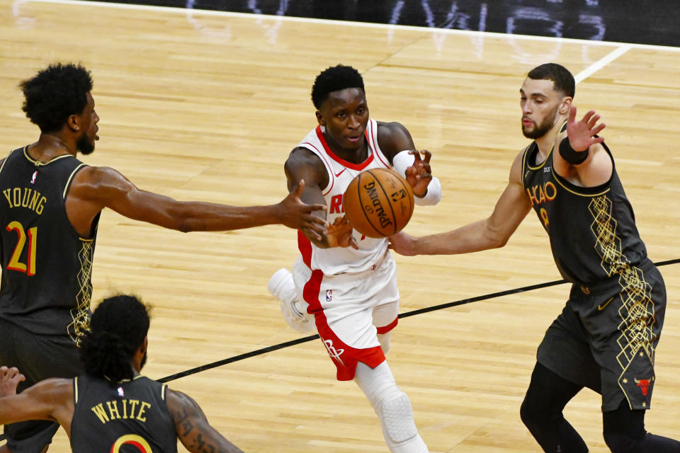 Victor Oladipo passes between Chicago Bulls forward Thaddeus Young and guard Zach LaVine.