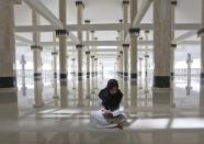 <p>A Muslim woman reads the Quran in a mosque on the third day of Ramadan in Jakarta, Indonesia, May 29, 2017. (AP Photo/Tatan Syuflana) </p>