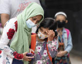 A student is comforted by her mother as she waits to enter PS 179 elementary school in the Kensington neighborhood, Tuesday, Sept. 29, 2020, in the Brooklyn borough of New York. Hundreds of thousands of elementary school students are heading back to classrooms Tuesday as New York City enters a high-stakes phase of resuming in-person learning during the coronavirus pandemic. (AP Photo/Mark Lennihan)