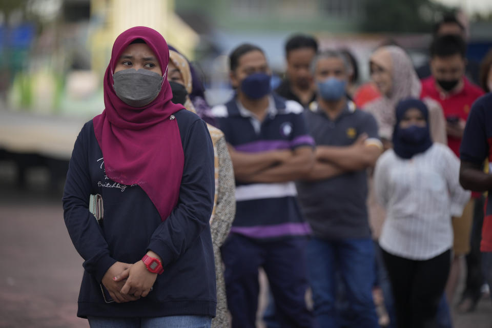 People queue up to enter a polling station to give their vote during the election in Seberang Perai, Penang state, Malaysia, Saturday, Nov. 19, 2022. Malaysians began casting ballots Saturday in a tightly contested national election that will determine whether the country's longest-ruling coalition can make a comeback after its electoral defeat four years ago. (AP Photo/Vincent Thian)