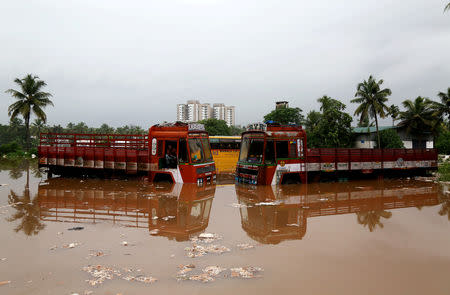 FILE PHOTO: Partially submerged trucks are surrounded by floodwaters at a parking bay after the opening of Idamalayr, Cheruthoni and Mullaperiyar dam gates following heavy rains, on the outskirts of Kochi, August 16, 2018. REUTERS/Sivaram V/File Photo